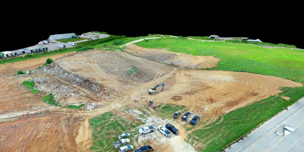 3D model of an excavated earthwork site with equipment and parked trucks beside green fields