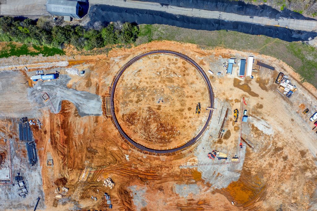 Top-down view of a circular foundation ring for a large structure on a red clay site