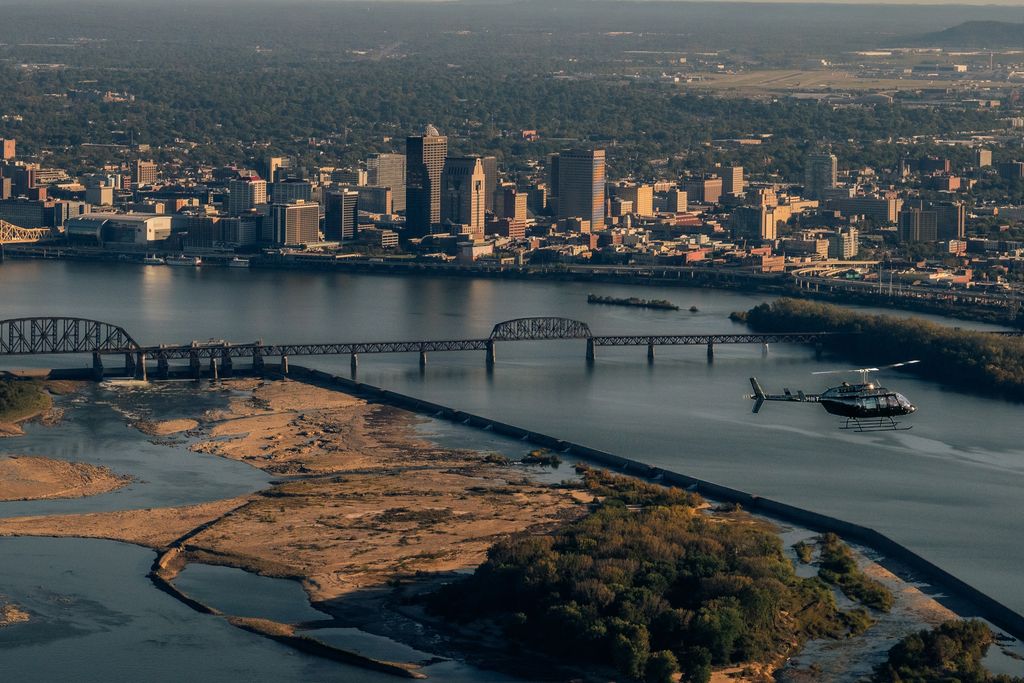 Helicopter flying low over the Ohio River with the Louisville skyline behind it