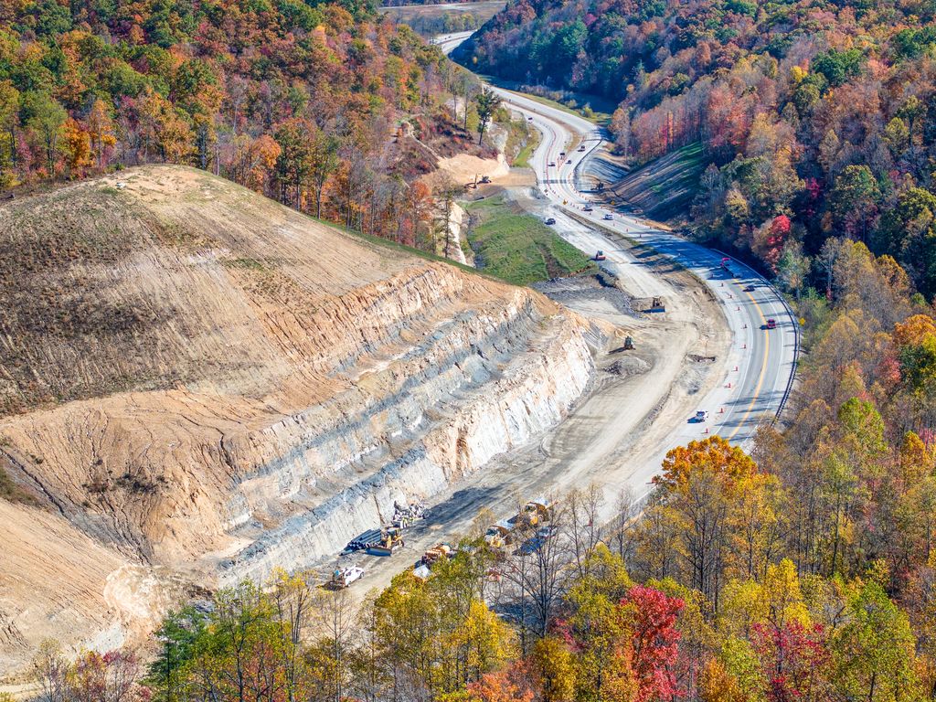 Construction on the Mountain Parkway cutting through a hillside in autumn forest