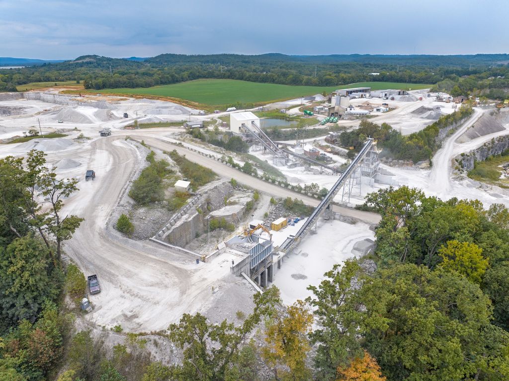 Quarry processing plant and conveyors framed by early autumn trees