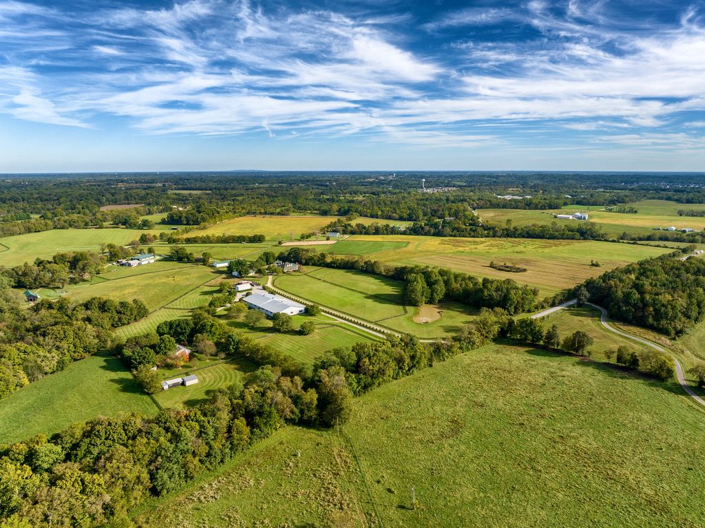 Rolling Kentucky farmland, pastures and tree lines under wispy clouds