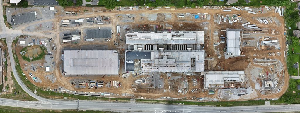 Top-down drone photo of hospital buildings rising on a graded construction site