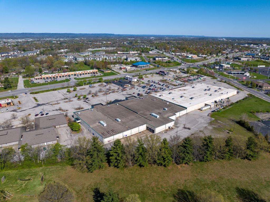 Vacant shopping center and parking lot beside a wooded slope in Southern Indiana